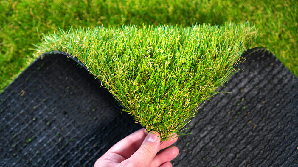 Hand Holding an Artificial Grass Roll. 