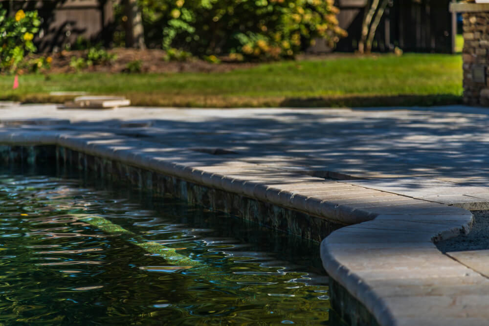 A Pool and a Travertine Patio Under Construction in a Backyard