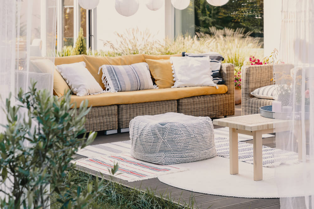 Stylish Outdoor Relax Area With Garden Furniture and Comfortable Pouf