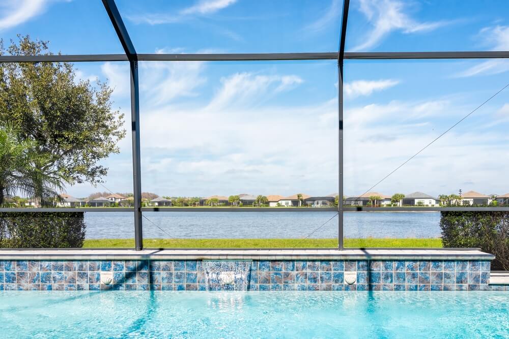 Modern Contemporary Home Screened Glass Lanai Private Pool Spa With View of Tropical Lake in Florida With Blue Water in Clean House