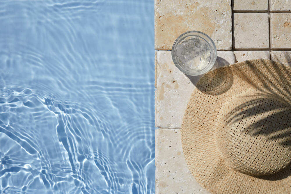 Hat on the Travertine Stone by the Beautiful Swimming Pool