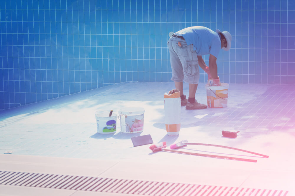 Man in a Hat Put the Tiles on the Bottom of the Pool in the Sunlight 