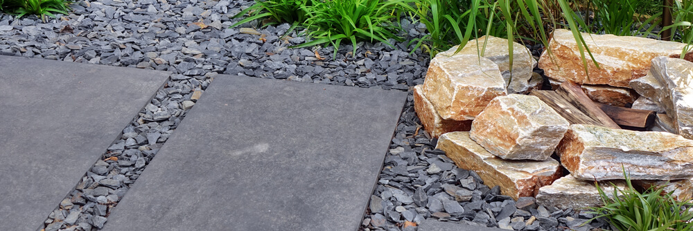 Fireplace From Limestone in Designed Alpine Backyard Garden With Tiled Footpath.