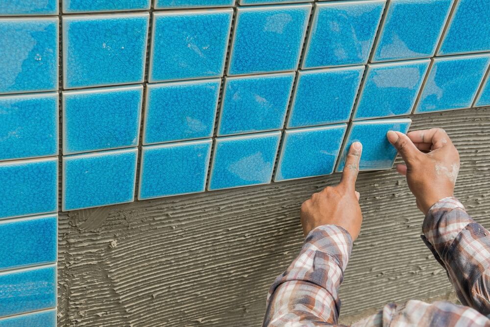 The Man Hand While Using Spacer for Installing Tiles. 